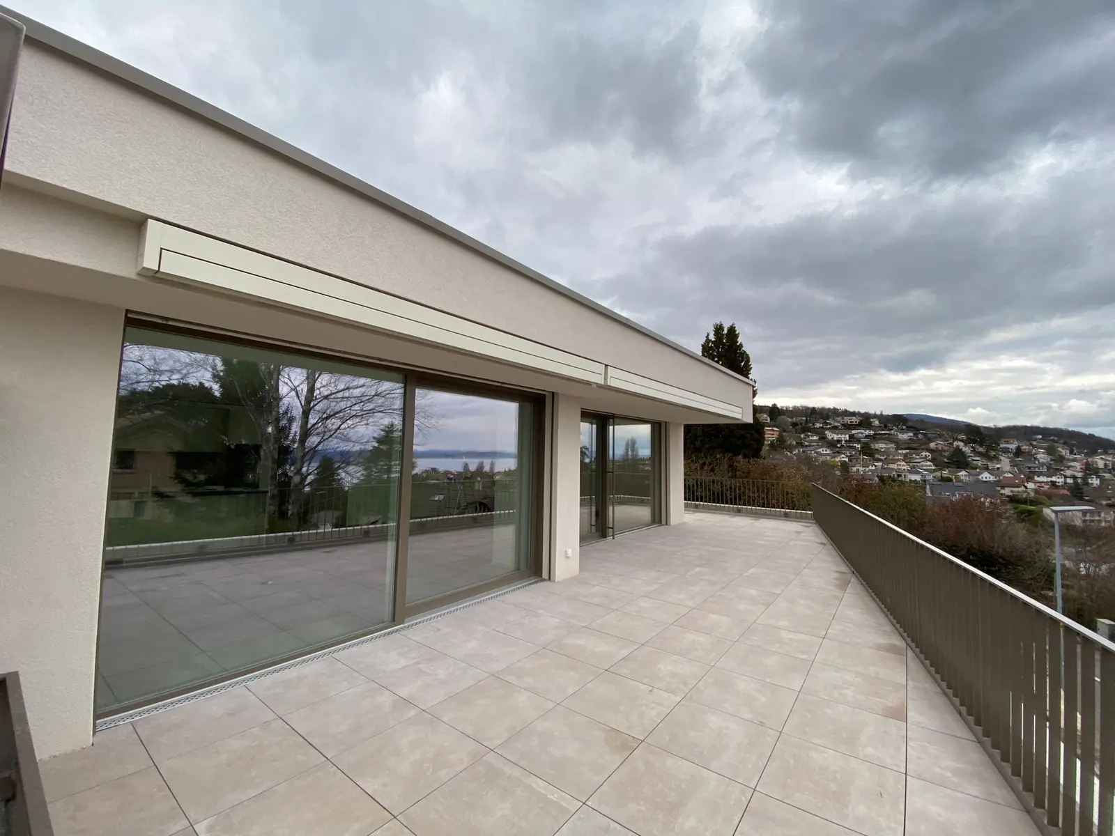 Baies coulissantes grises sur une terrasse panoramique