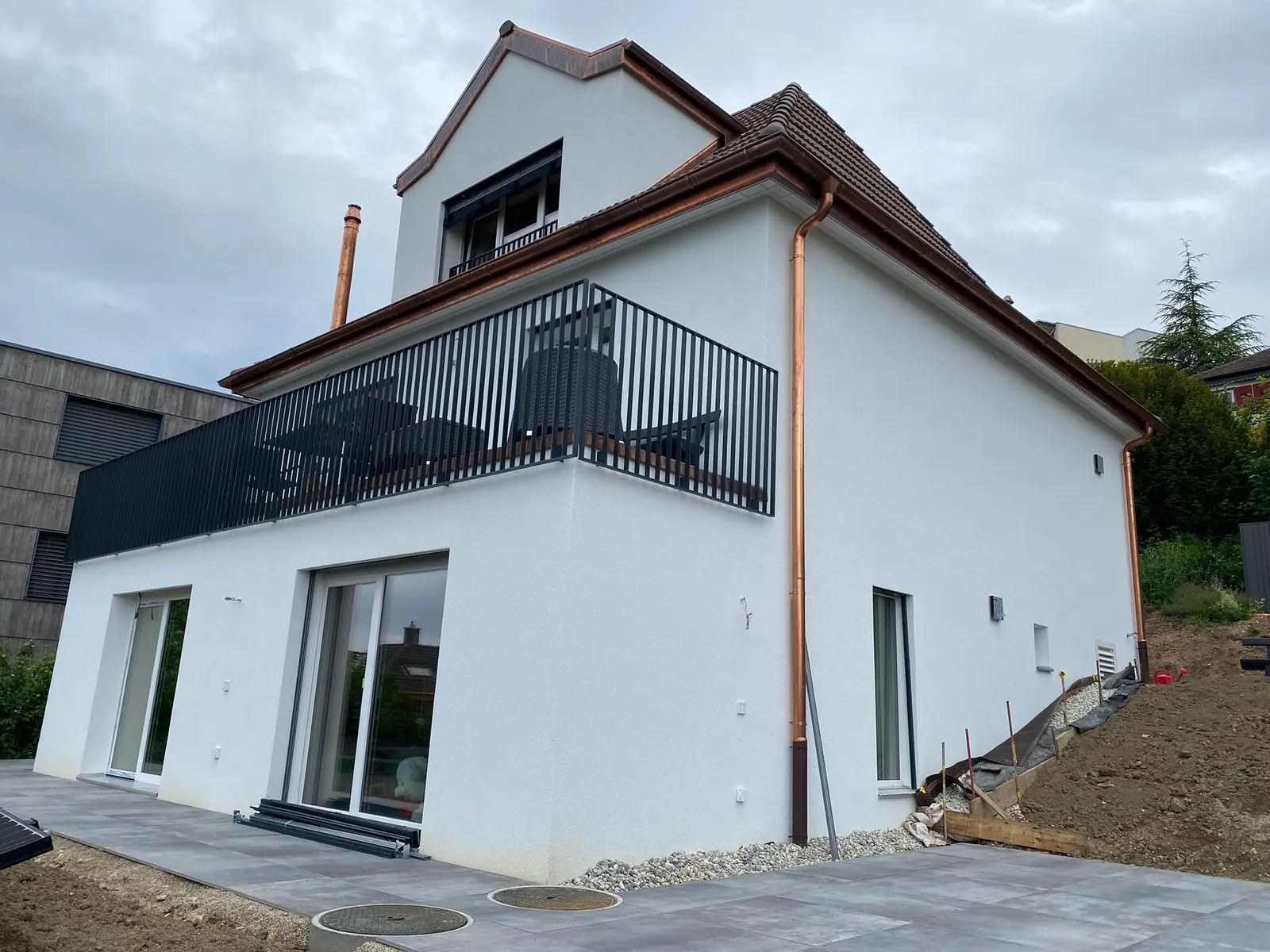 Villa blanche avec porte-fenêtre et balcon anthracite
